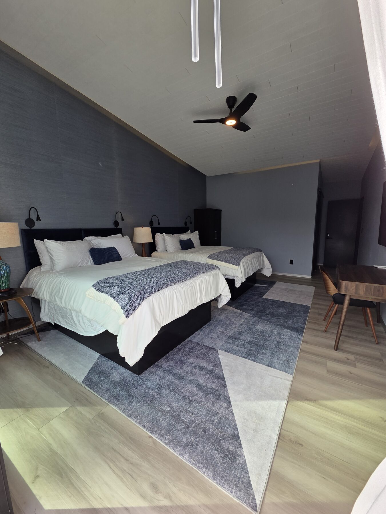 Double queen suite with two queen beds and geometric rug