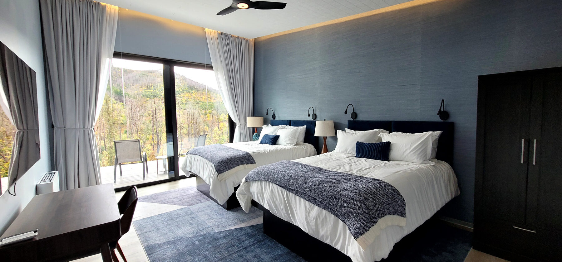 Two-queen suite with autumn forest view